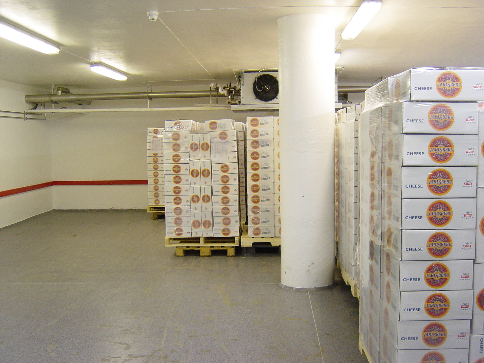 Produksjonslokaler med ost stablet i en reol. Vegg og gulv malt med epoksy