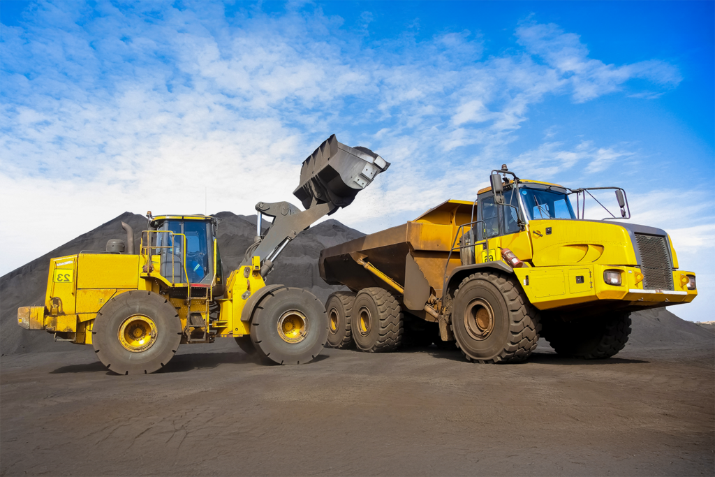 machinery and dumping trucks outside a coal mining