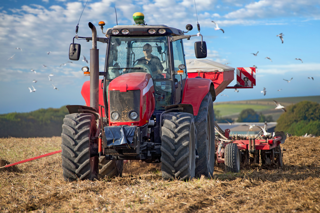 tractor pulling drill sowing wheat seed in field