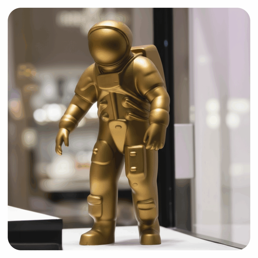 liten statue av en astronaut, gullfarget