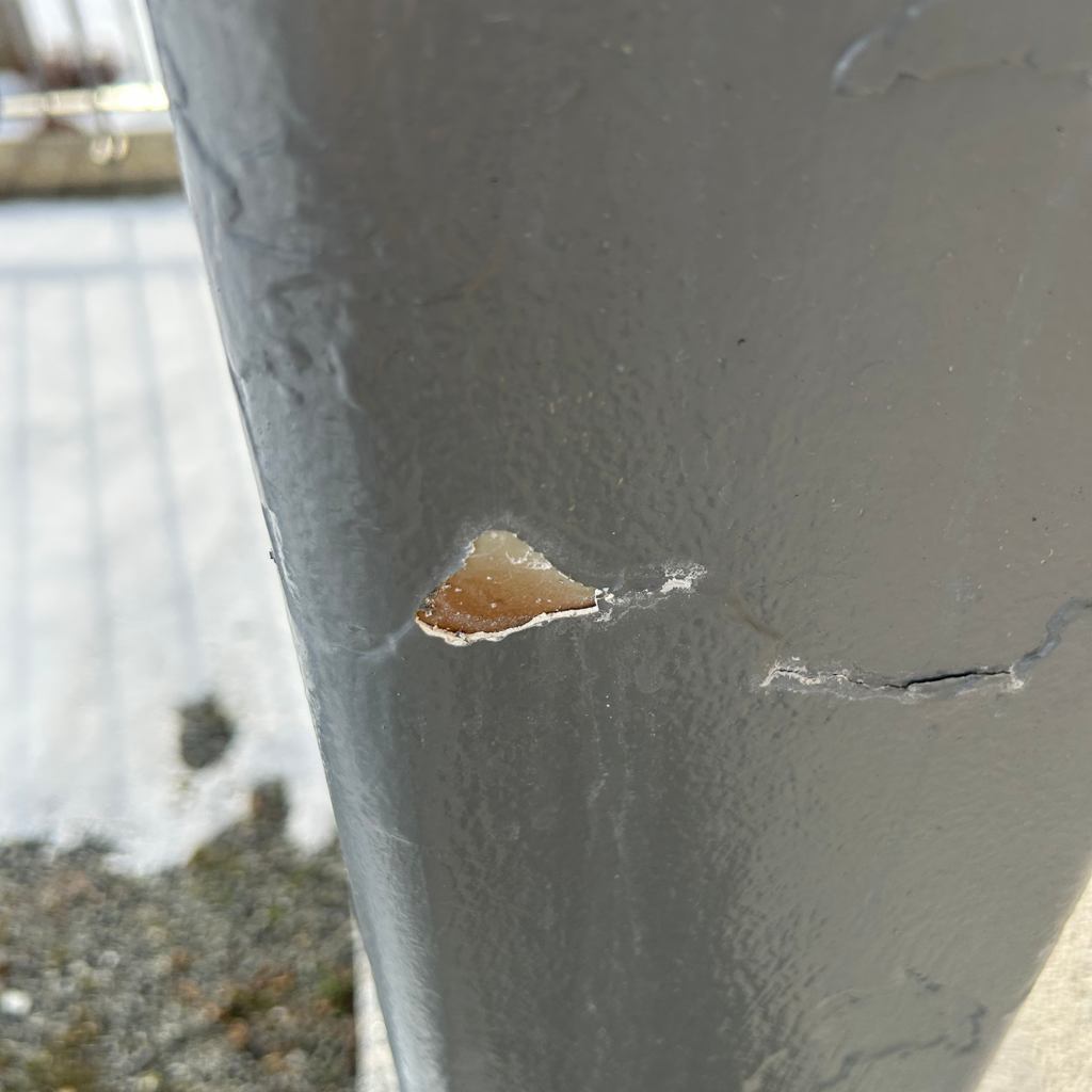 nærbilde av flasset maling på stålelementer