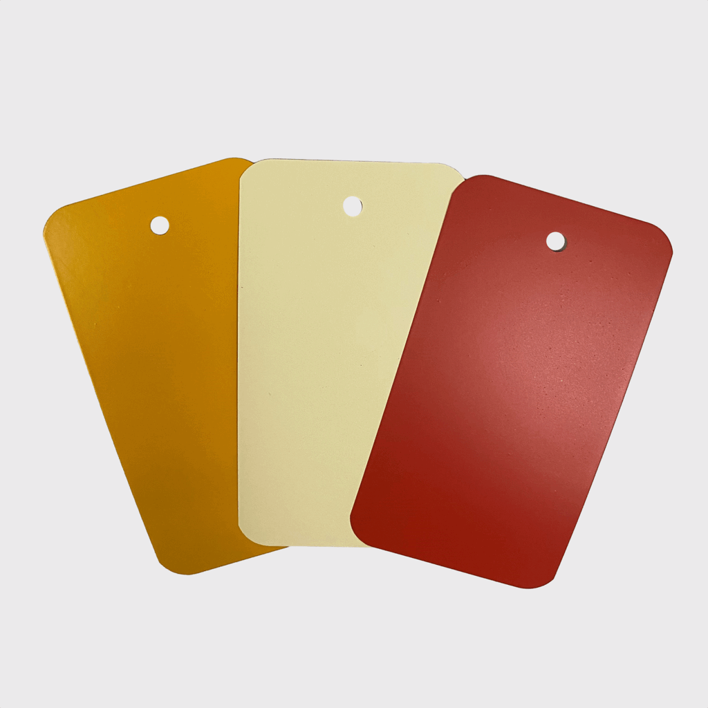 3 små metallplater med fargeprøve i oransje-beige-rød